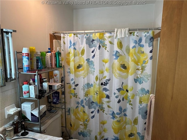 bathroom featuring curtained shower and toilet