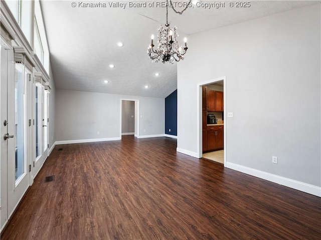 spare room featuring visible vents, baseboards, lofted ceiling, dark wood-style flooring, and a chandelier