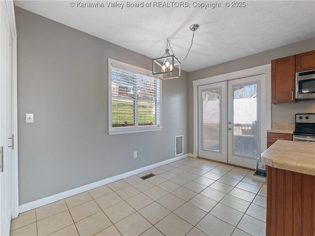 unfurnished dining area with light tile patterned floors, french doors, visible vents, and a textured ceiling