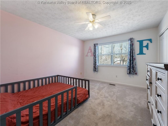 bedroom featuring visible vents, ceiling fan, baseboards, light carpet, and a textured ceiling