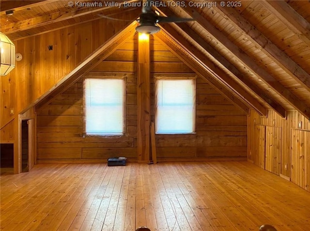 bonus room with wooden walls, wooden ceiling, lofted ceiling with beams, and hardwood / wood-style floors