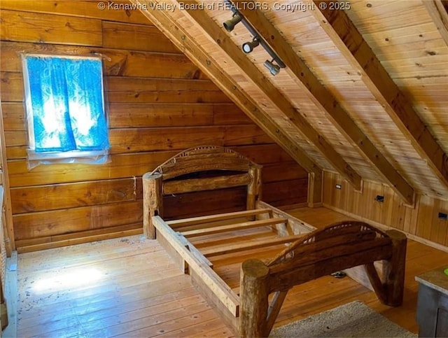 unfurnished bedroom with hardwood / wood-style floors, a sauna, lofted ceiling, rail lighting, and wood walls