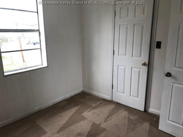 carpeted spare room featuring baseboards