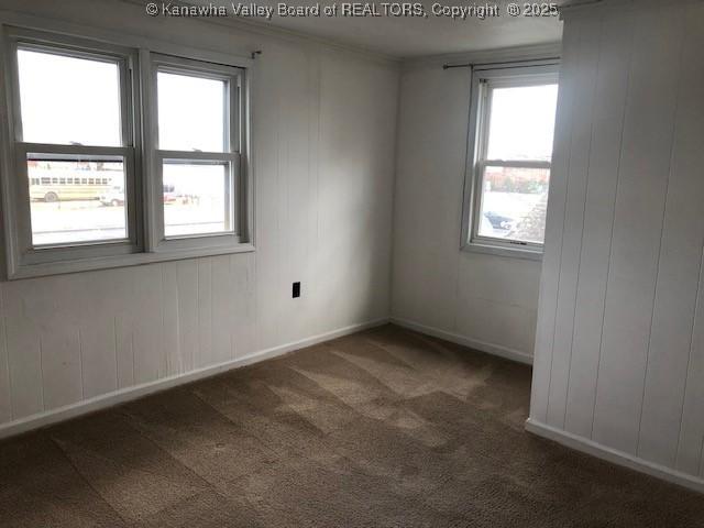 spare room featuring carpet flooring and baseboards