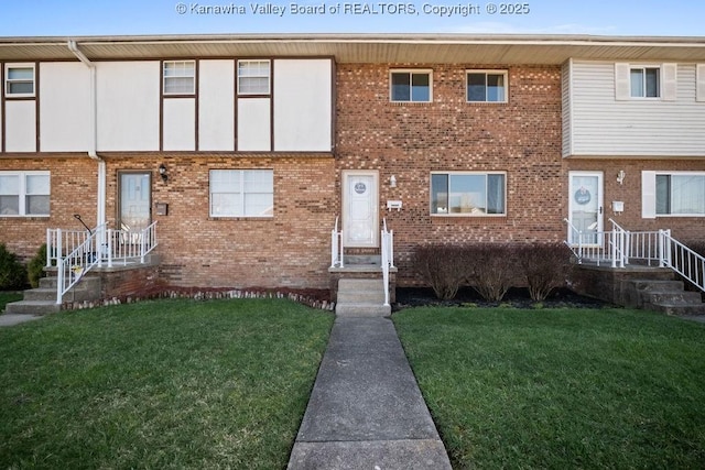 multi unit property featuring brick siding and a front yard