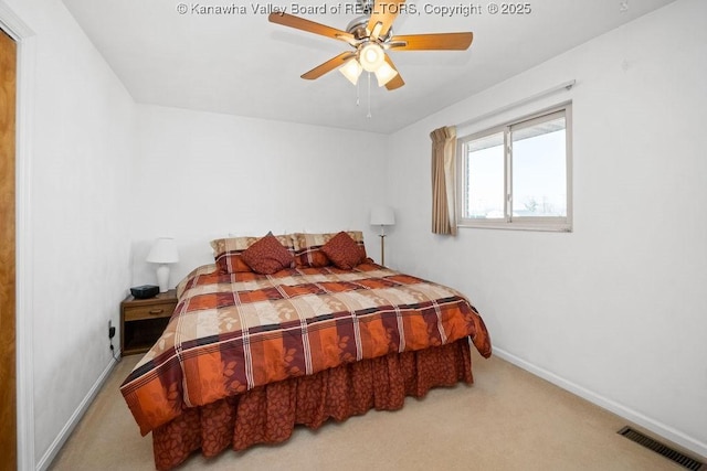 carpeted bedroom with visible vents, a ceiling fan, and baseboards