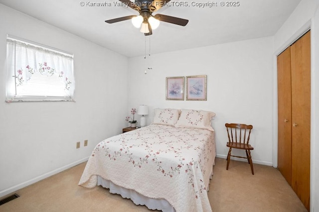 bedroom with baseboards, visible vents, light carpet, and a closet