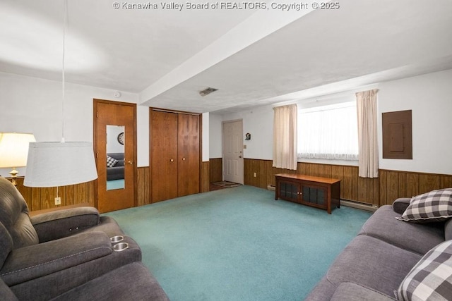 living area featuring wooden walls, carpet floors, electric panel, baseboard heating, and wainscoting