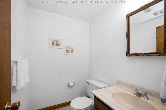 bathroom featuring visible vents, toilet, vanity, and baseboards