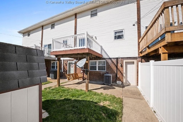 rear view of house featuring a patio area, fence, central AC unit, and brick siding