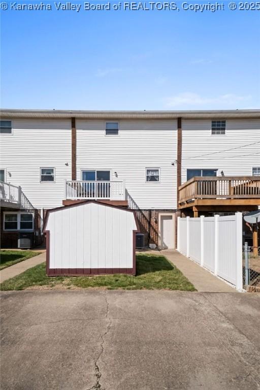 rear view of house featuring stairway, fence, central AC, and a deck