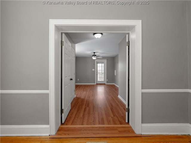 corridor featuring wood finished floors and baseboards