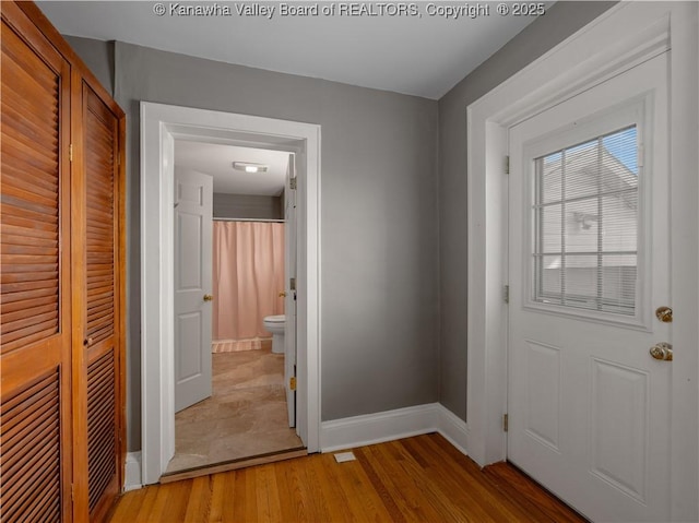 entryway with baseboards and light wood-style floors