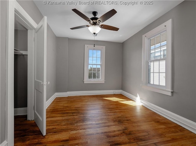 unfurnished bedroom featuring a ceiling fan, wood finished floors, and baseboards