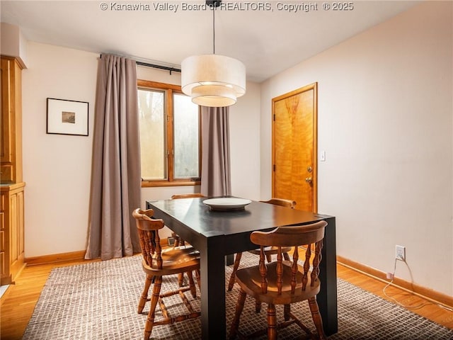 dining area featuring baseboards and light wood-style floors