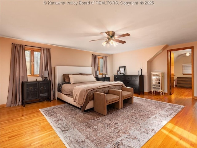 bedroom with ceiling fan, baseboards, and light wood-style flooring