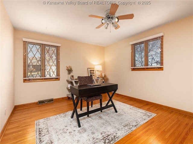 office space featuring visible vents, baseboards, and wood finished floors