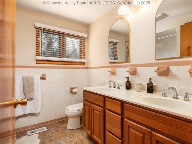 bathroom featuring visible vents, toilet, and a sink