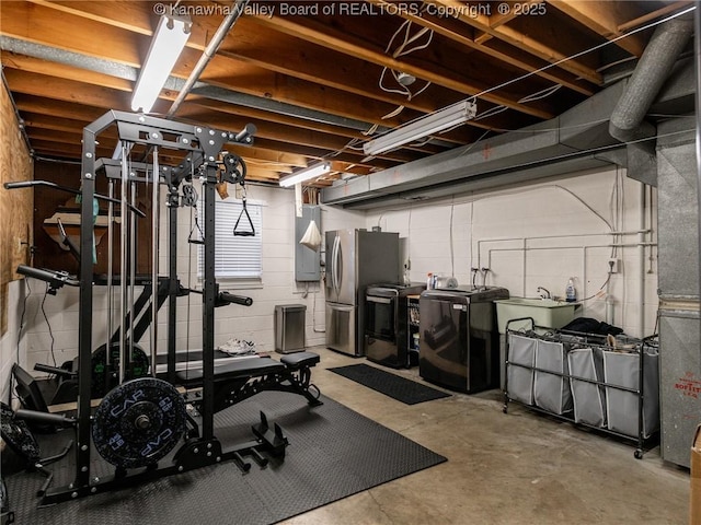 workout room featuring washing machine and clothes dryer and a sink