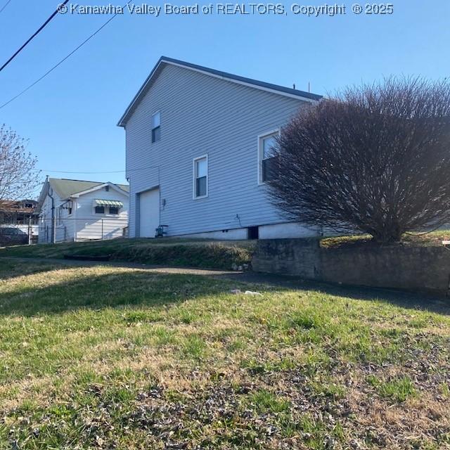 back of property with a lawn and an attached garage