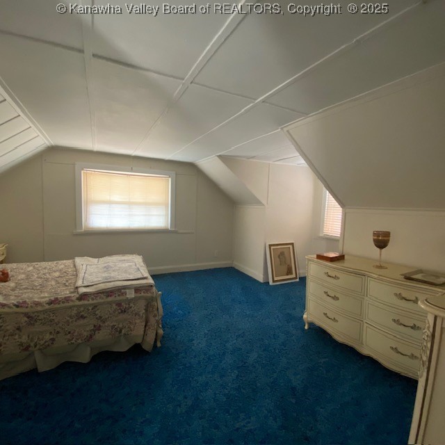 unfurnished bedroom featuring vaulted ceiling and carpet floors