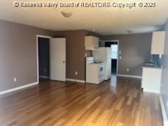 unfurnished living room featuring baseboards and wood finished floors