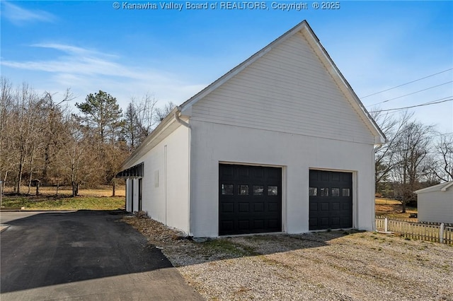 detached garage featuring fence