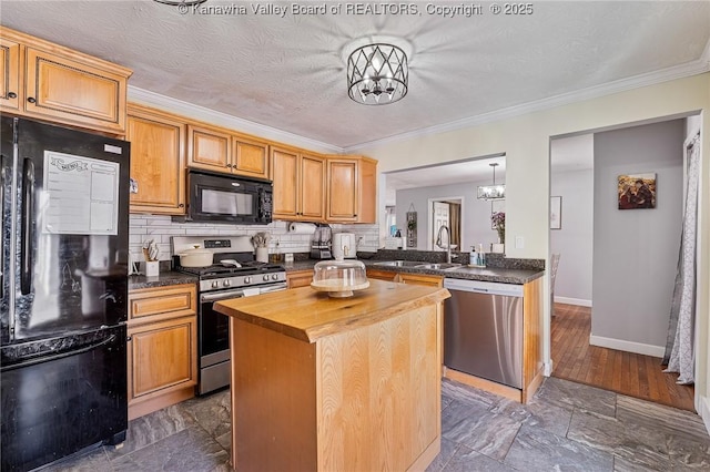 kitchen featuring black appliances, a sink, a center island, an inviting chandelier, and butcher block counters