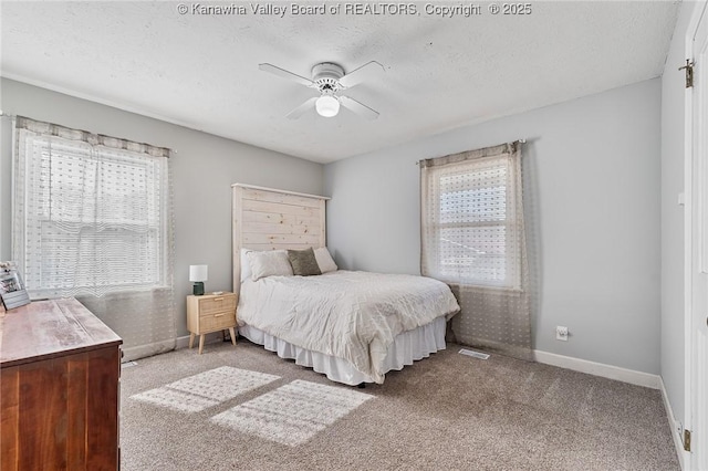 bedroom with multiple windows, baseboards, carpet floors, and a textured ceiling