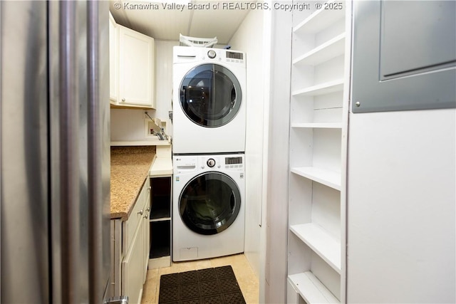 laundry room featuring cabinet space and stacked washer and dryer