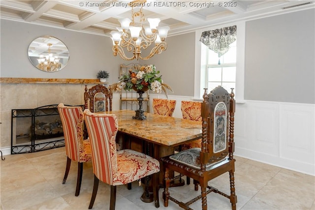 dining room with beam ceiling, a fireplace, visible vents, and wainscoting