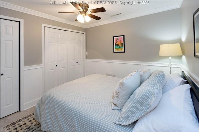 bedroom with crown molding, visible vents, a wainscoted wall, and ceiling fan