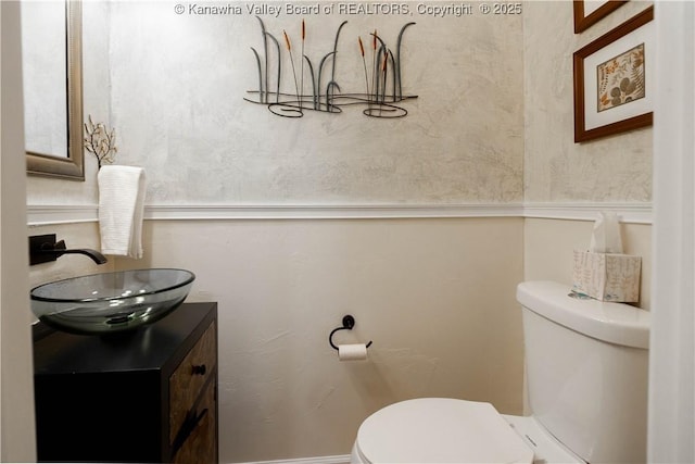 half bathroom with vanity and toilet