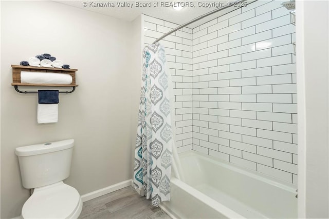 bathroom with shower / bathtub combination with curtain, toilet, baseboards, and wood finished floors