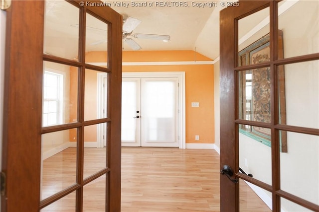 entryway with french doors, light wood-style floors, baseboards, ceiling fan, and vaulted ceiling