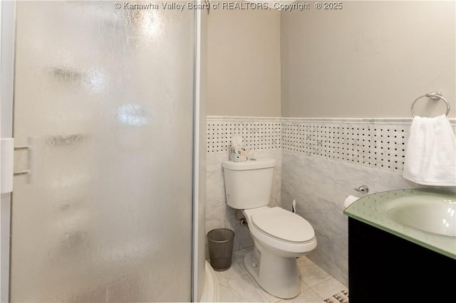 full bath with toilet, tile walls, a stall shower, and vanity