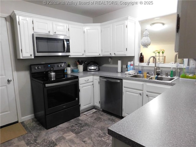 kitchen featuring white cabinets, appliances with stainless steel finishes, and a sink