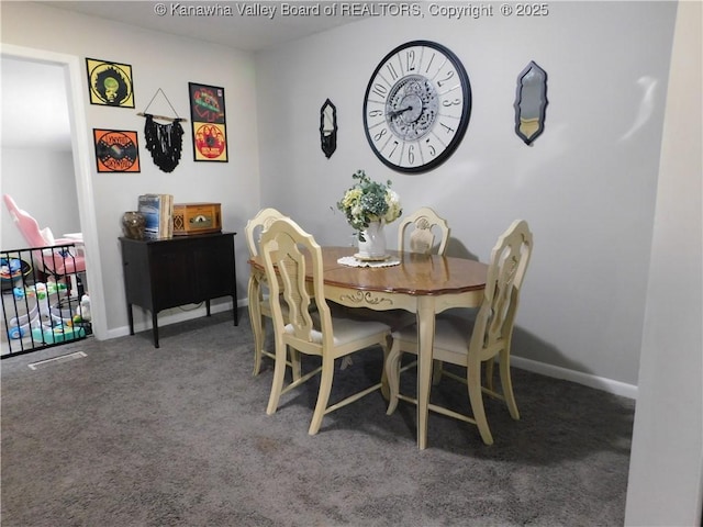 carpeted dining room featuring baseboards