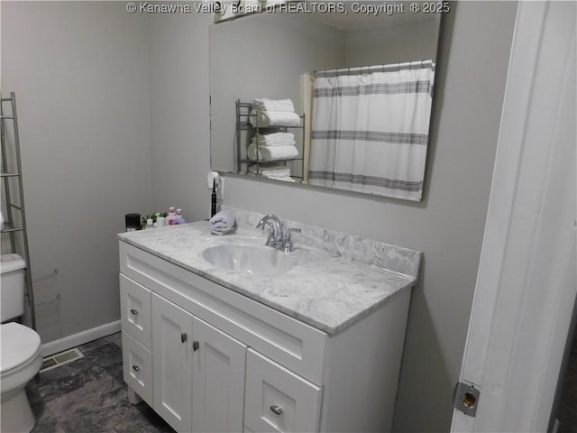 bathroom featuring visible vents, baseboards, toilet, and vanity