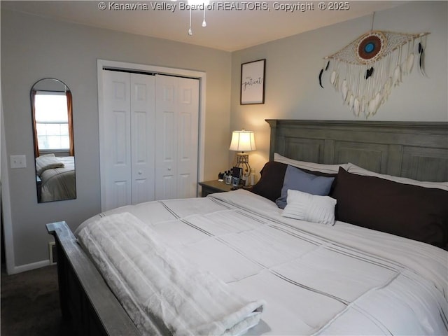 carpeted bedroom with a closet and baseboards