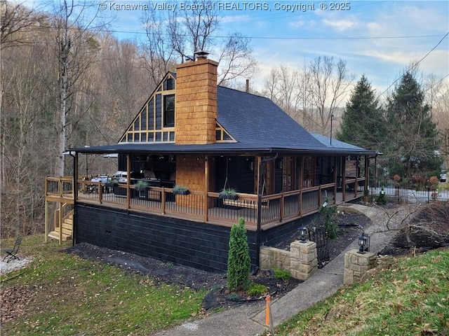 view of side of home featuring roof with shingles and a chimney