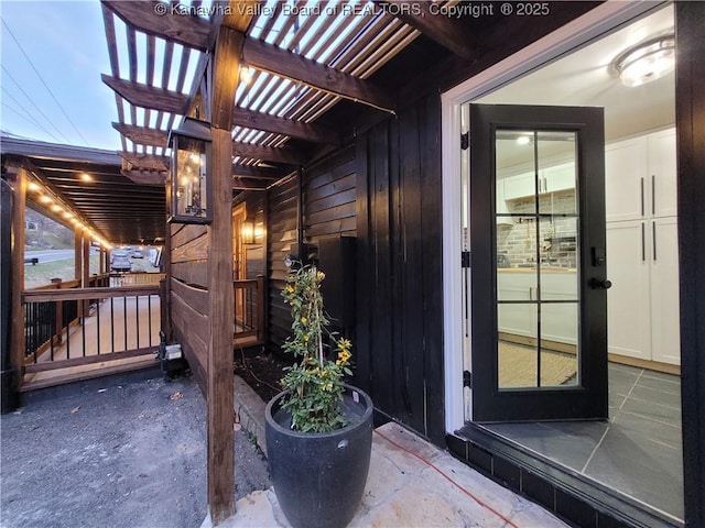 view of exterior entry featuring a pergola