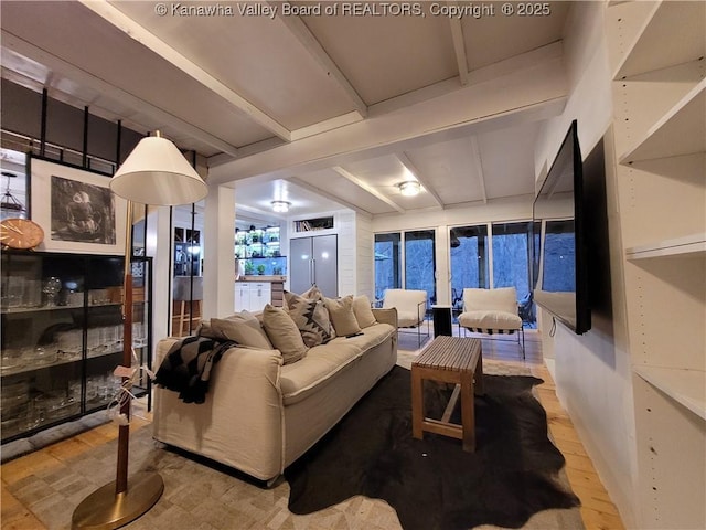 living room featuring beamed ceiling and wood finished floors