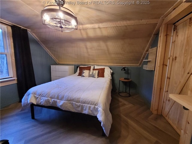 bedroom with parquet floors and lofted ceiling