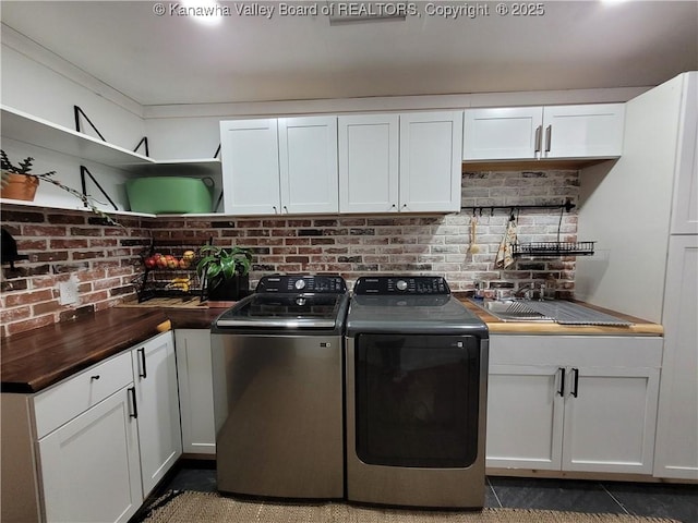 clothes washing area with cabinet space and independent washer and dryer