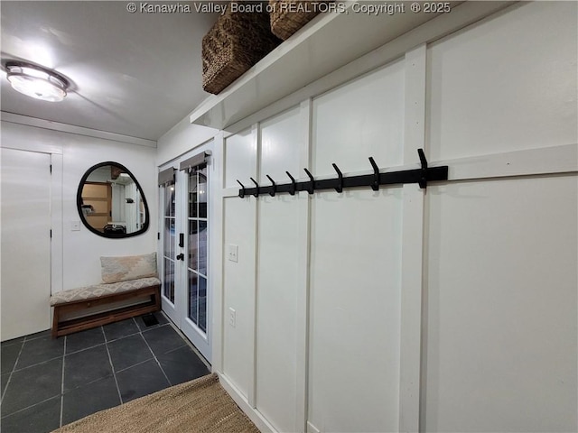 mudroom with dark tile patterned flooring