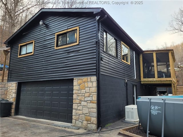 view of home's exterior featuring stone siding and driveway