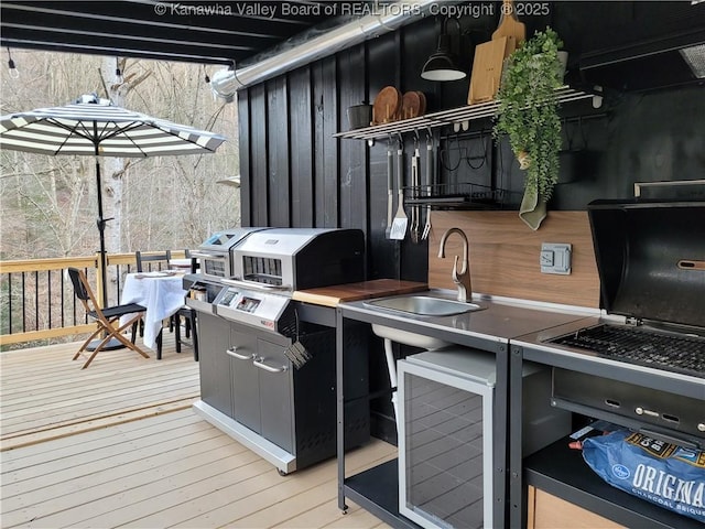 deck featuring area for grilling, beverage cooler, and a sink