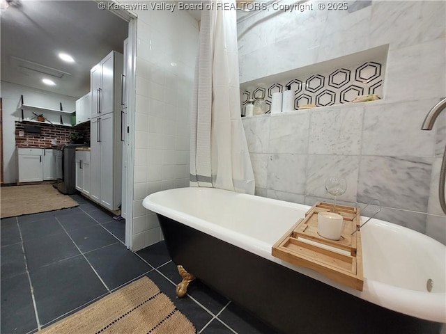 bathroom featuring tile patterned flooring, a freestanding bath, vanity, recessed lighting, and tile walls