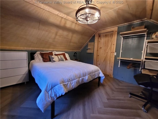 bedroom featuring lofted ceiling and a notable chandelier